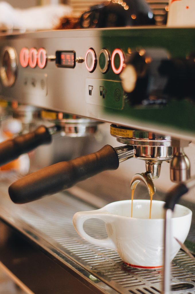 close up of la marzocco pb espresso machine with one espresso shot pouring into one cup